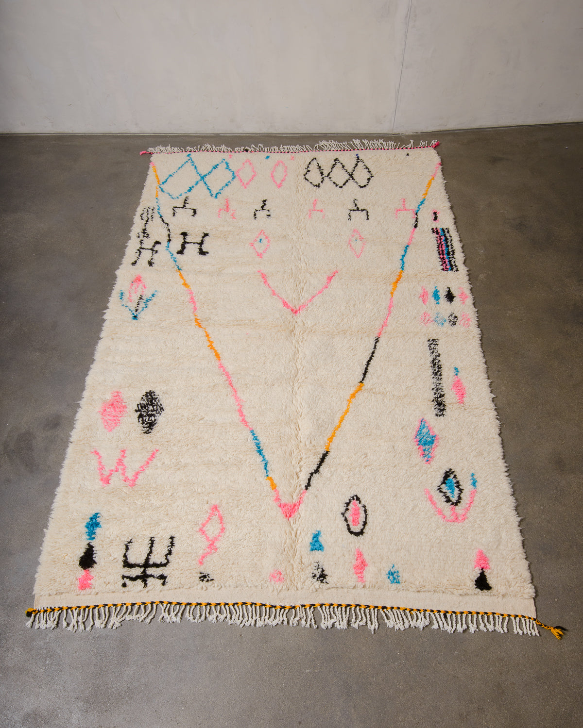 Berberlin Azilal rug made of fluffy wool and cotton, laying flat on a concrete floor.